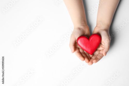 Woman holding red heart in hands on white background  top view