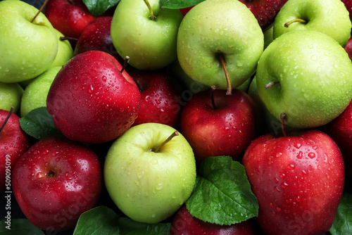 Fresh ripe green and red apples with water drops as background, top view photo