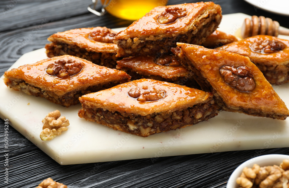Delicious sweet baklava with walnuts on black wooden table, closeup Delicious sweet baklava with walnuts on black wooden table, closeup