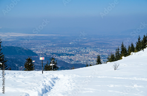 Wintertime landscape high in the Carpathian mountains of Romania , with Brasov City panorama in the background
