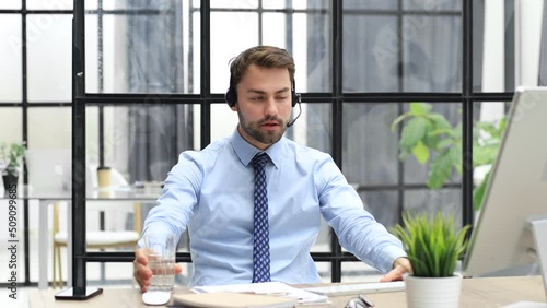 Confident businessman wearing headset speaking and watching business webinar training, listening to lecture. Call operator customer support service at distance online
