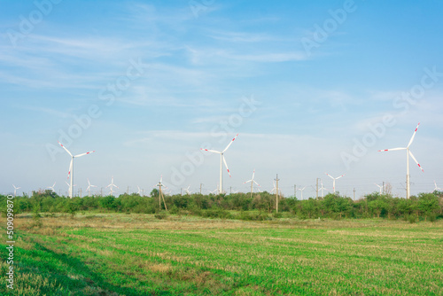 Wind turbines generators on green meadow. Source of alternative electricity. Ecological renewable power sources