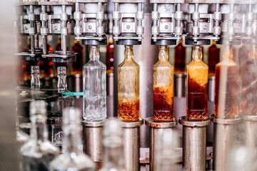 Alcohol beverage factory. Bottles on conveyor belt of bottle filling machine