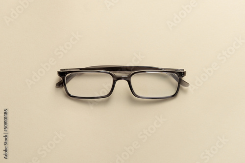 Top view of reading glasses on a cream table