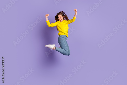 Full body profile side photo of young girl jump celebrate luck fists hands awesome isolated over purple color background