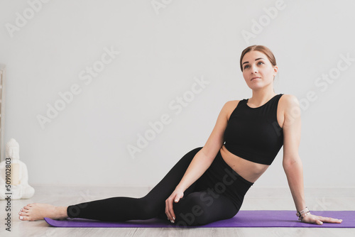 adorable woman sit on yoga mats , practicing meditation and yoga at home