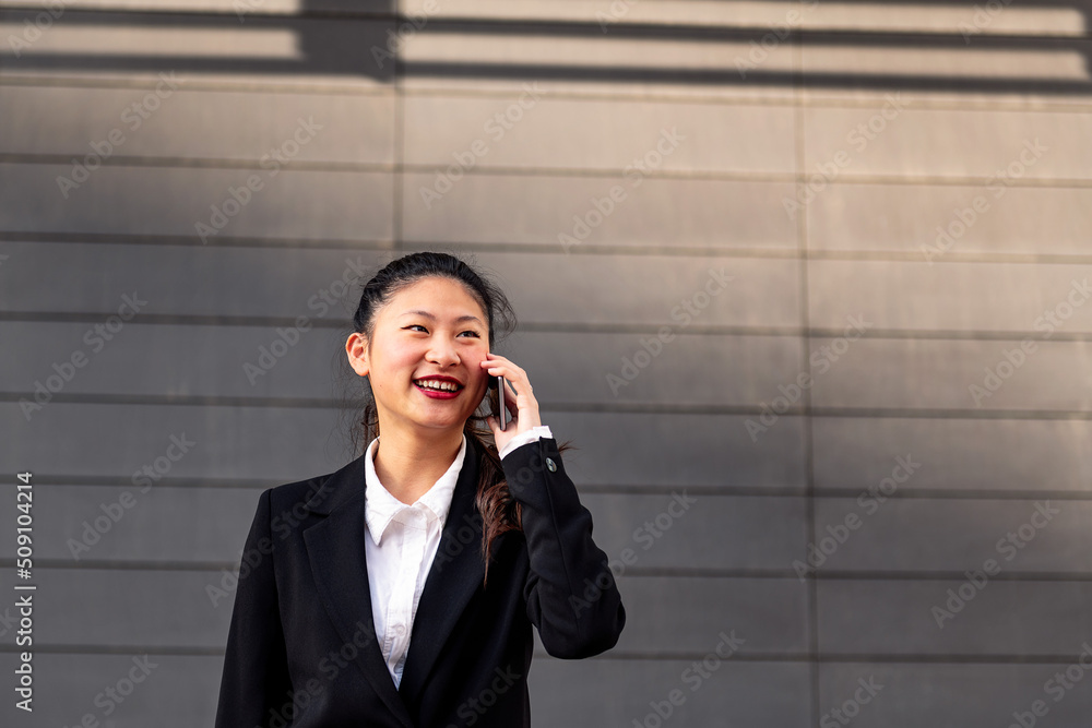 smiling asiatic businesswoman talking on the phone, concept of entrepreneurship and business, copy space for text