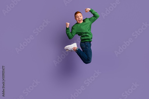 Full body profile side photo of young man jump up celebrate luck fists hands isolated over violet color background