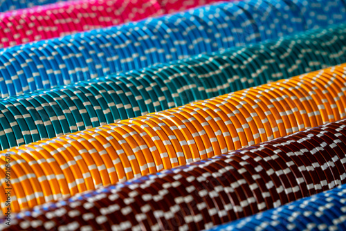 Rows of colored casino chips. Close up of set of green  blue  yellow and pink chips for playing poker  craps  roulette  blackjack. Background of gambling  betting  winning money.