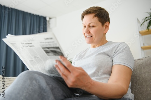 woman sitting reading the newspaper at home.