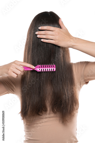 A woman combing the hair over her face on a white studio background