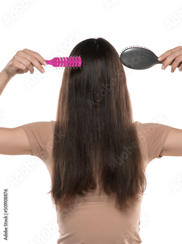 A woman combing the hair over her face on a white studio background