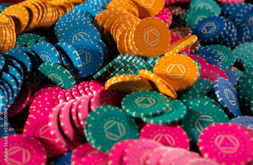 Background of colored casino chips. Close up set of yellow, green, blue and pink casino chips for playing roulette, poker, blackjack. Background of gambling, money chips, betting, winning.