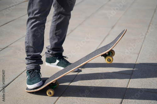 a foot holding a skateboard on the concrete floor