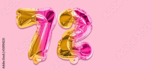 Rainbow foil balloon number, digit seventy two on a pink background. Birthday greeting card with inscription 72. Top view. Numerical digit. Celebration event, template. Banner