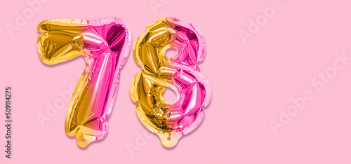 Rainbow foil balloon number, digit seventy eight on a pink background. Birthday greeting card with inscription 78. Top view. Numerical digit. Celebration event, template. Banner