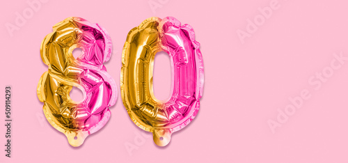 Rainbow foil balloon number, digit eighty on a pink background. Birthday greeting card with inscription 80. Anniversary concept. Top view. Numerical digit. Celebration event, template. Banner