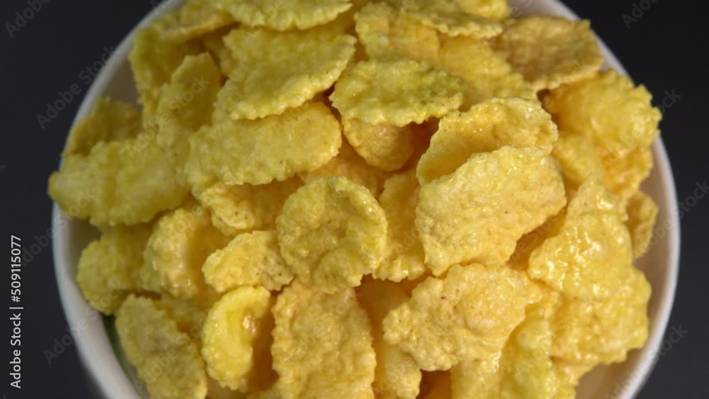 Crispy corn flakes rotating in bowl close up, dry healthy breakfast. Honey cornflakes for healthy cereal breakfast. Cooking healthy breakfast concept. High quality 4k footage Crispy corn flakes rotating in bowl close up, dry healthy breakfast. Honey cornflakes for healthy cereal breakfast. Cooking healthy breakfast concept. High quality 4k footage