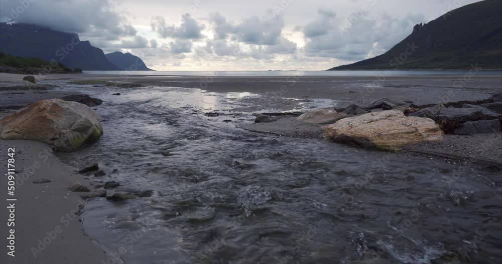 Scenic beach creek runs into sea, storviksanden, Norway Scenic beach creek runs into sea, storviksanden, Norway