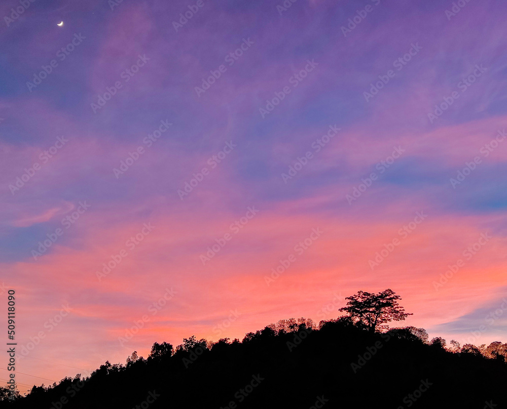 sunset in the mountains and moon in the sky