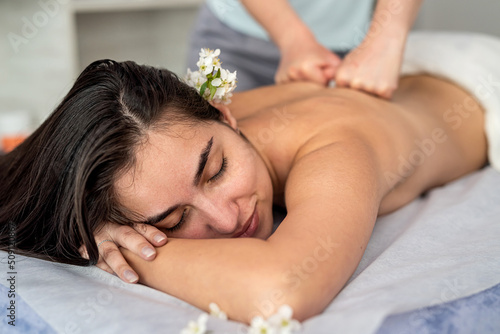 beautiful woman receive restorative massage on her back in spa salon