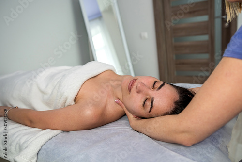 Osteopath makes manual neck massage her female client in spa centre.