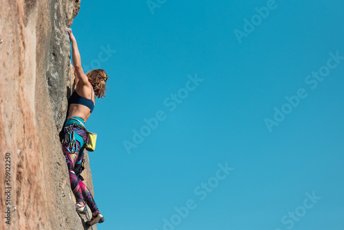 The sports girl is engaged in rock climbing
