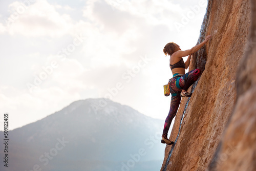 A woman climbs a rock © zhukovvvlad