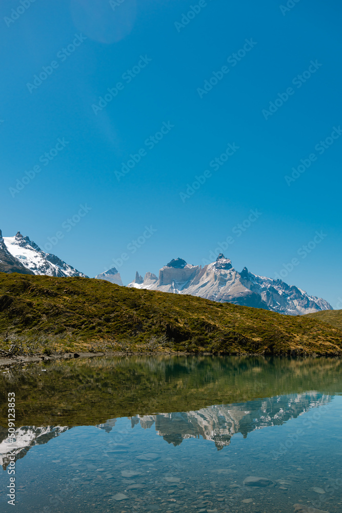 Guernos mountains reflected in Pehoe lake with clear blue sky, Torres del Paine National Park  in Chile