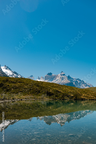 Guernos mountains reflected in Pehoe lake with clear blue sky, Torres del Paine National Park  in Chile photo