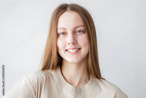 Portrait of young beautiful cute cheerful girl smiling over white background © Tatyana Gladskih