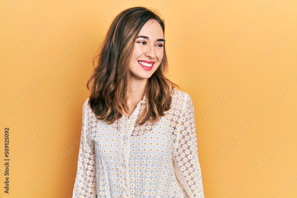 Young hispanic girl wearing casual clothes looking away to side with smile on face, natural expression. laughing confident. Young hispanic girl wearing casual clothes looking away to side with smile on face, natural expression. laughing confident.