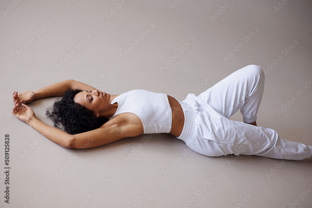 Sexy curly woman doing stretching on white background. Young girl in white clothes isolated Sexy curly woman doing stretching on white background. Young girl in white clothes isolated