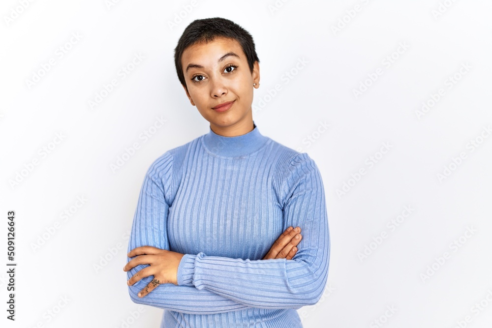 Young hispanic woman with short hair standing over isolated background relaxed with serious expression on face. simple and natural looking at the camera. Young hispanic woman with short hair standing over isolated background relaxed with serious expression on face. simple and natural looking at the camera.
