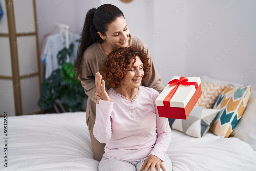 Two women mother and daughter surprise with gift Two women mother and daughter surprise with gift