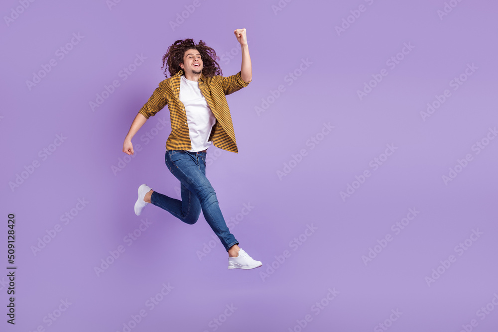 Full body profile side photo of young man go walk run hurry discount isolated over purple color background Full body profile side photo of young man go walk run hurry discount isolated over purple color background