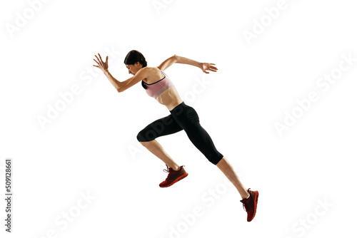 Young caucasian woman running isolated on white studio background. One female runner or jogger. Sport, track-and-field athletics, competition concept