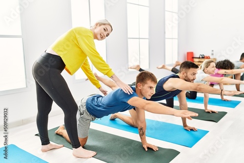 Group of young people smiling happy training with personal trainer at sport center.