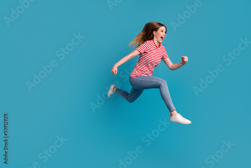 Fototapeta Naklejka Na Ścianę i Meble -  Full size profile side photo of young excited woman run rush discount wear casual outfit isolated over blue color background