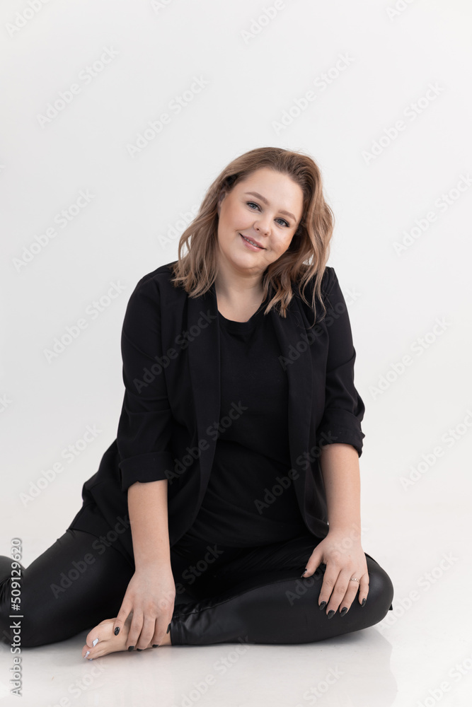 Vertical studio portrait of smiling woman looking at camera on white background. Female in her natural body positive. 