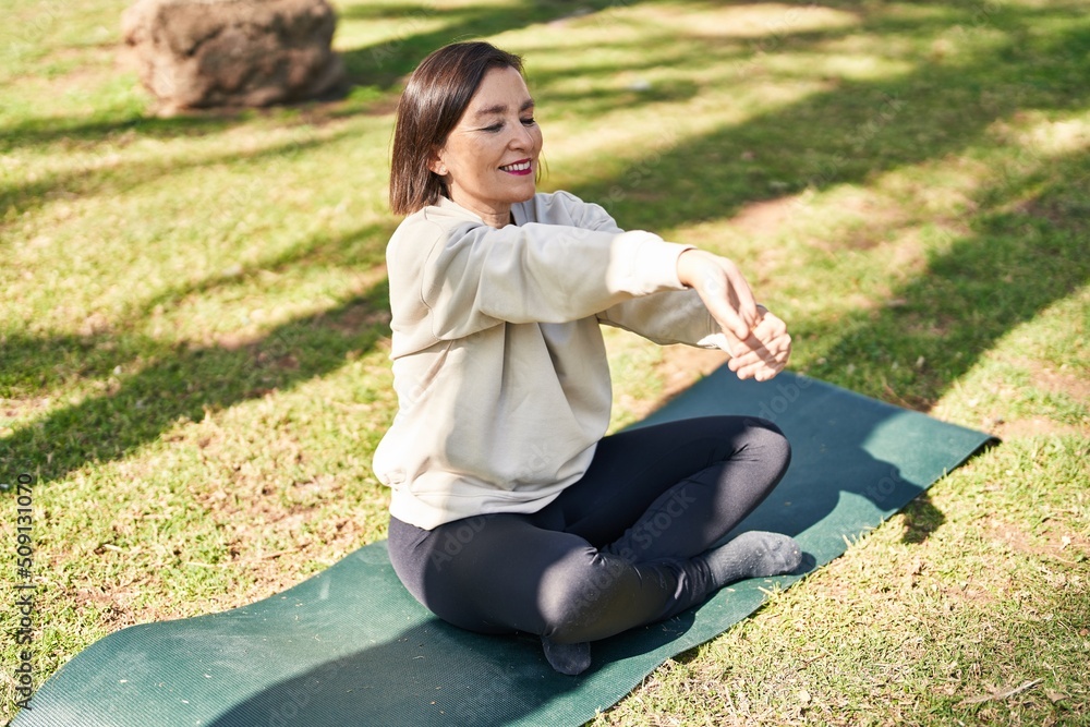 Middle age woman smiling confident stretching at park Middle age woman smiling confident stretching at park