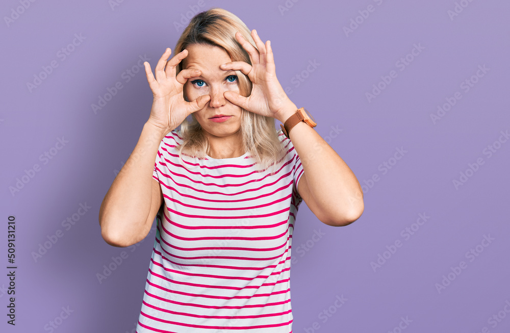 Young caucasian woman wearing casual clothes trying to open eyes with fingers, sleepy and tired for morning fatigue