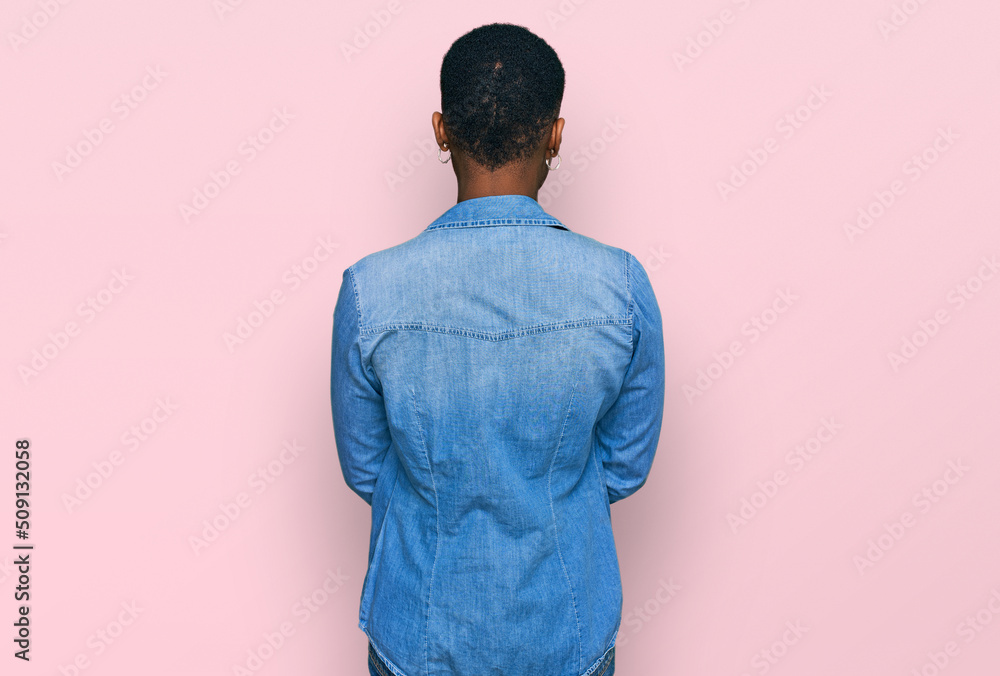 Young african american woman wearing casual clothes standing backwards looking away with crossed arms Young african american woman wearing casual clothes standing backwards looking away with crossed arms