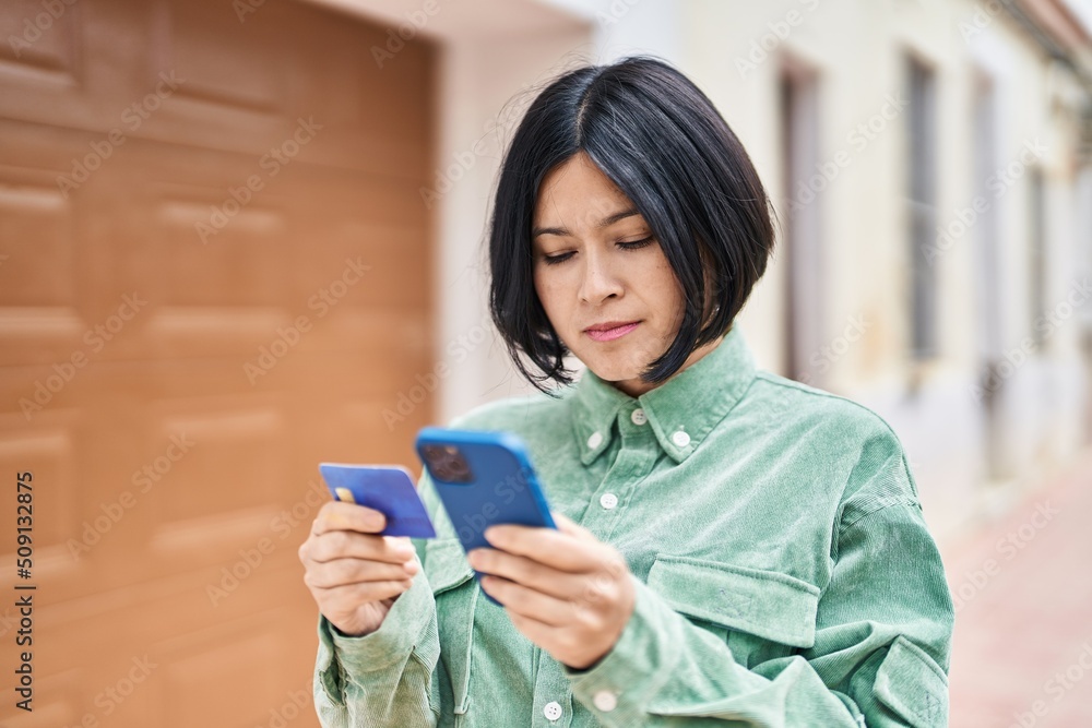 Young chinese woman using smartphone and credit card at street Young chinese woman using smartphone and credit card at street