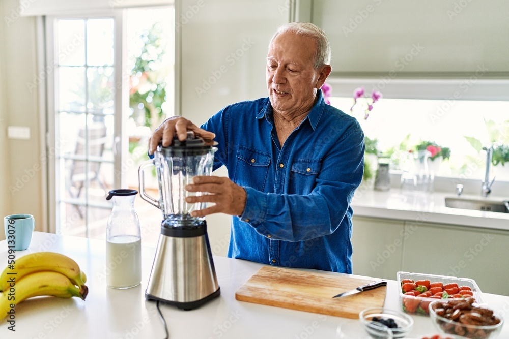 Senior man smiling confident using blender at kitchen Senior man smiling confident using blender at kitchen