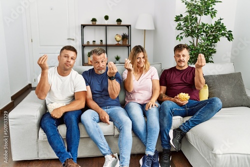 Group of middle age people sitting on the sofa at home doing italian gesture with hand and fingers confident expression