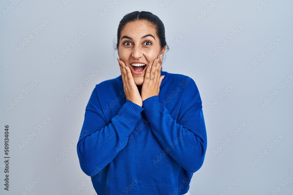 Young hispanic woman standing over isolated background afraid and shocked, surprise and amazed expression with hands on face Young hispanic woman standing over isolated background afraid and shocked, surprise and amazed expression with hands on face