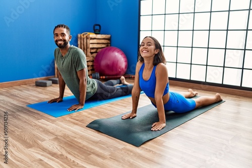 Man and woman couple smiling confident stretching at sport center