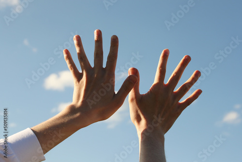 Young man hands and blue sky. Photo was taken 22 May 2022 year, MSK time in Russia.