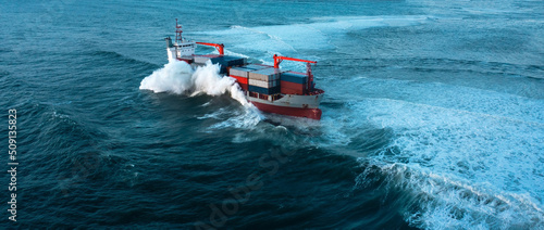 Stormy sea with Container ship delivering cargo at sunset photo